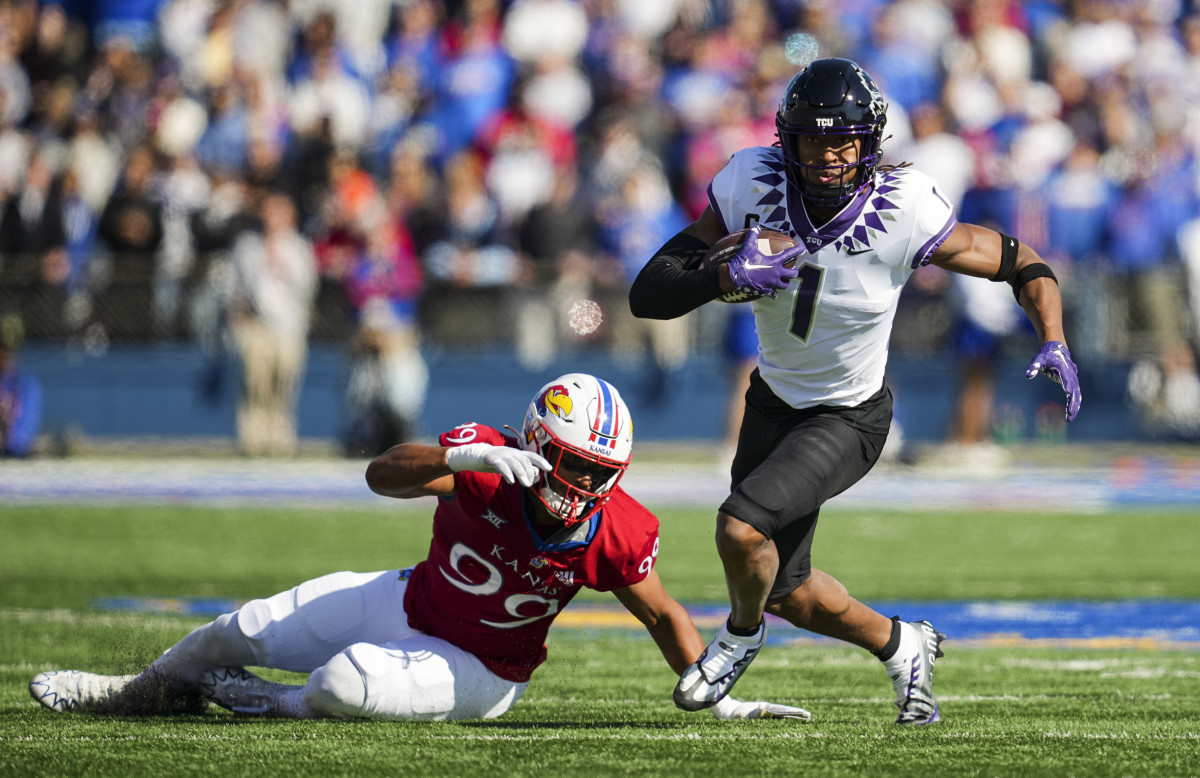 Oct 8, 2022; Lawrence, Kansas, USA; TCU Horned Frogs wide receiver Quentin Johnston (1) runs with the ball past Kansas Jayhawks defensive lineman Malcolm Lee (99) during the first half at David Booth Kansas Memorial Stadium. Mandatory Credit: Jay Biggerstaff-USA TODAY Sports